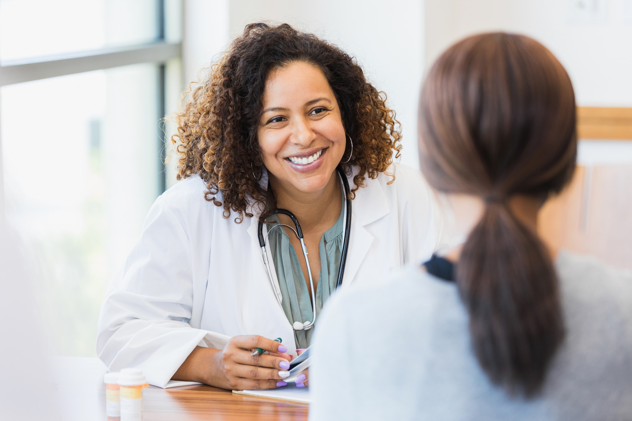 doctor smiling while sitting at her desk